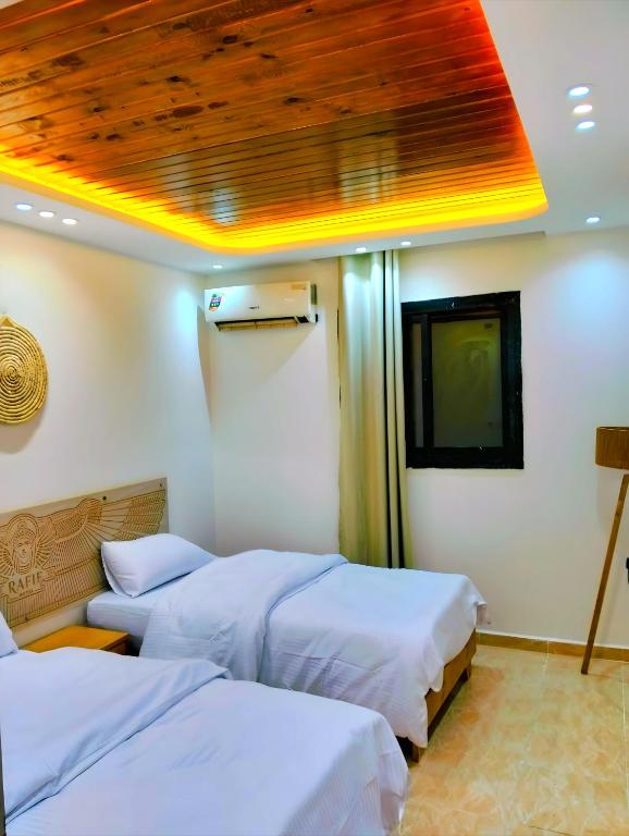 Postel nebo postele na pokoji v ubytování RAFiF PYRAMiDS APARTMENTS & SUiTES HOTEL
