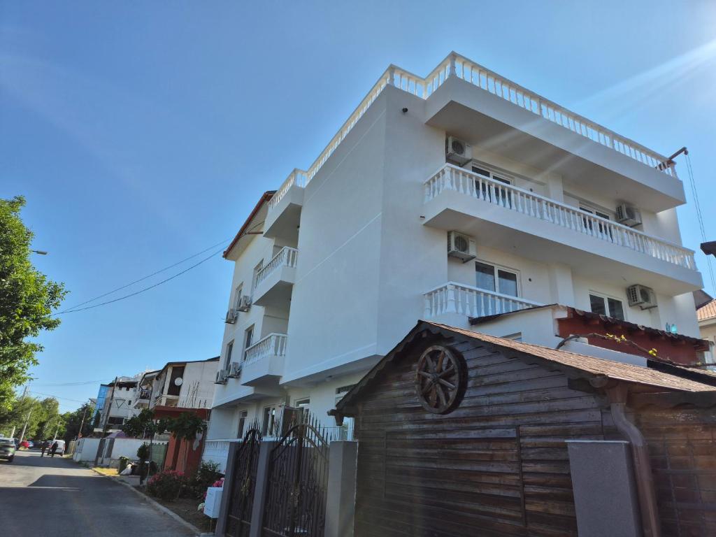 a tall white building with a balcony on a street at Casa Tatiana Eforie Nord in Eforie Nord
