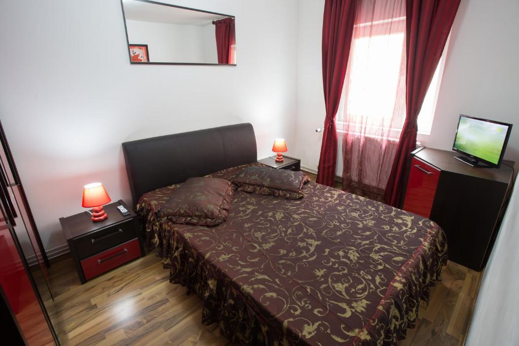 ブシュテニにあるApartament Confortの小さなベッドルーム(ベッド1台、鏡付)
