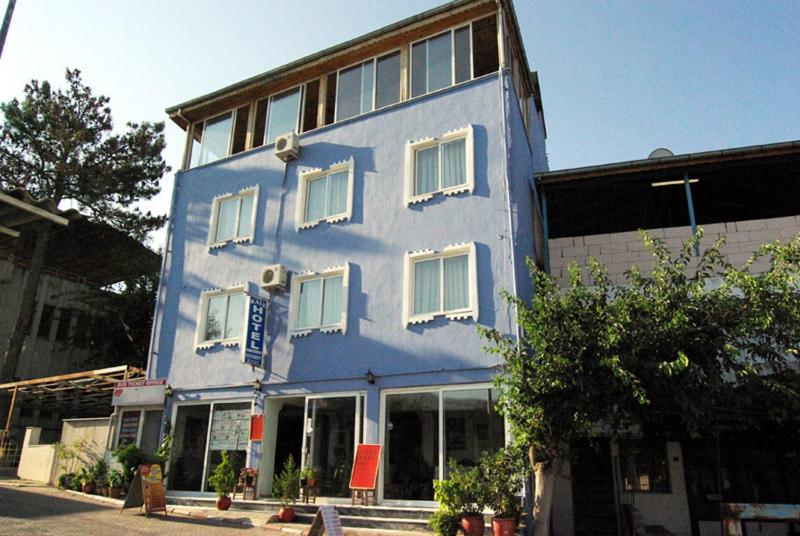 a blue building with white windows on a street at Kale Hotel in Pamukkale