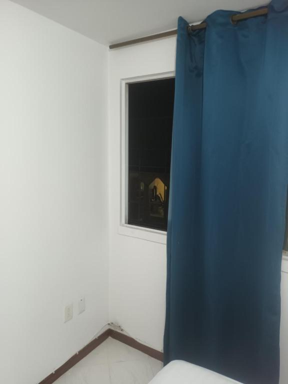 a blue curtain in a room with a window at Habitacion bucaramanga cañaveral piscina parqueadero turco in Floridablanca