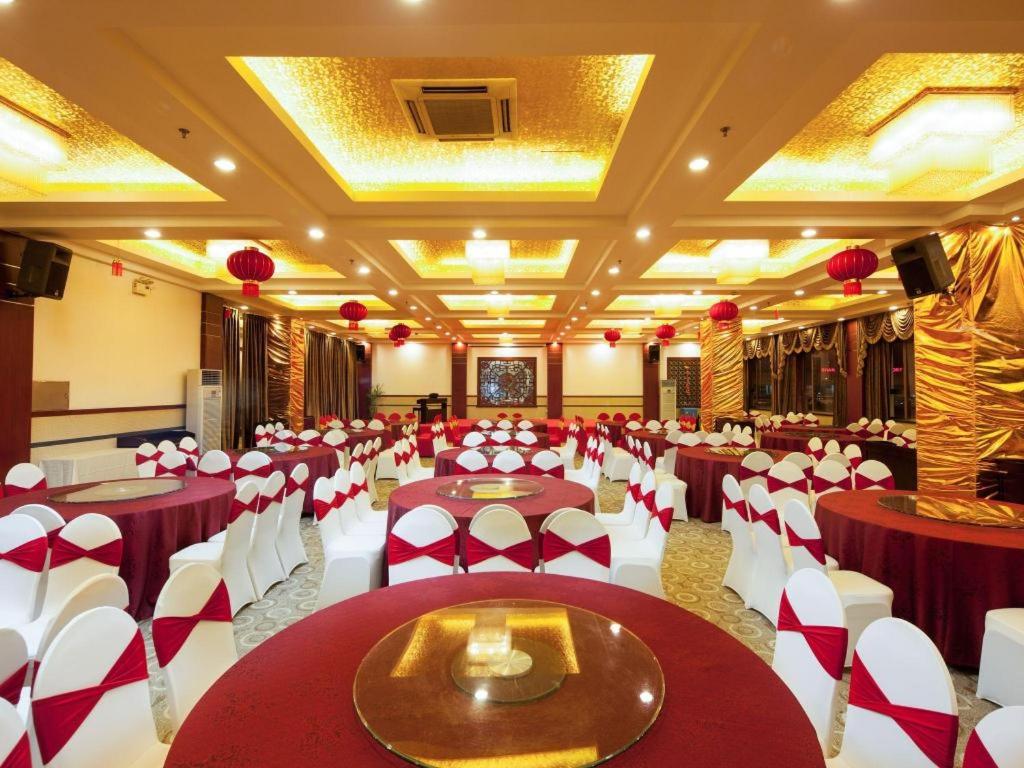 a banquet hall with red and white tables and chairs at Argyle International Airport Hotel Shanghai in Shanghai