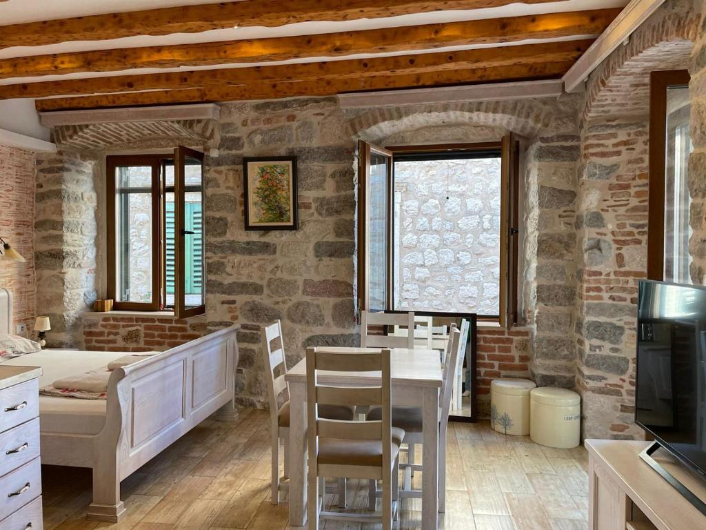 a living room with a table and chairs and a tv at Apartaments Charlie Chaplin in Kotor