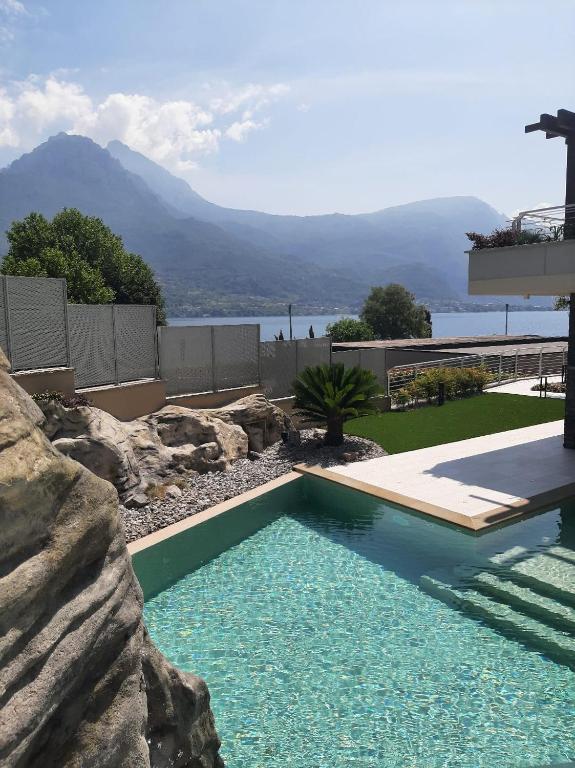 a swimming pool in a yard with a rock wall at Villa Orchidea in Onno