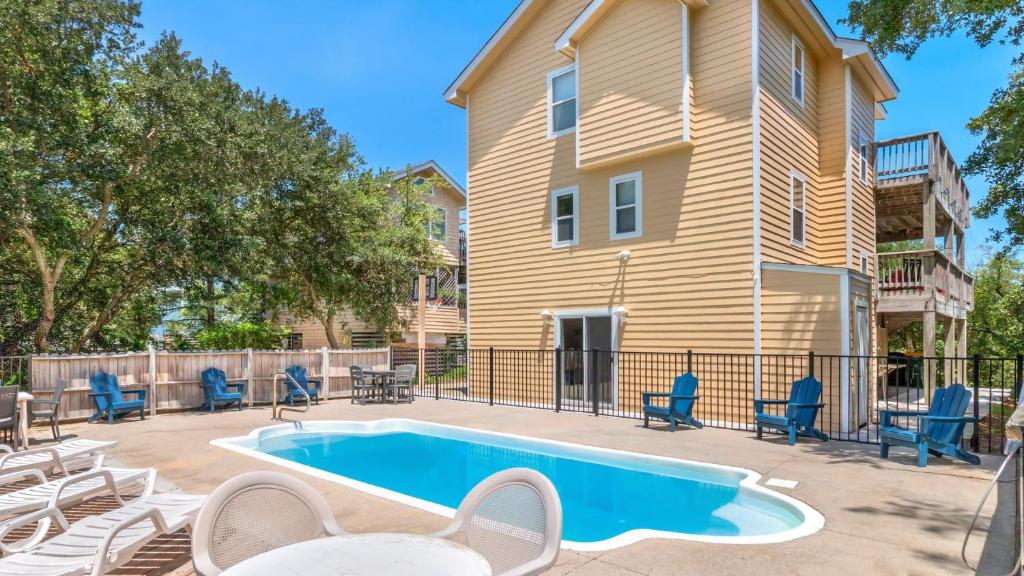 a swimming pool in a yard with chairs and a house at 1680 - Hopes and Dreams in Poplar Branch