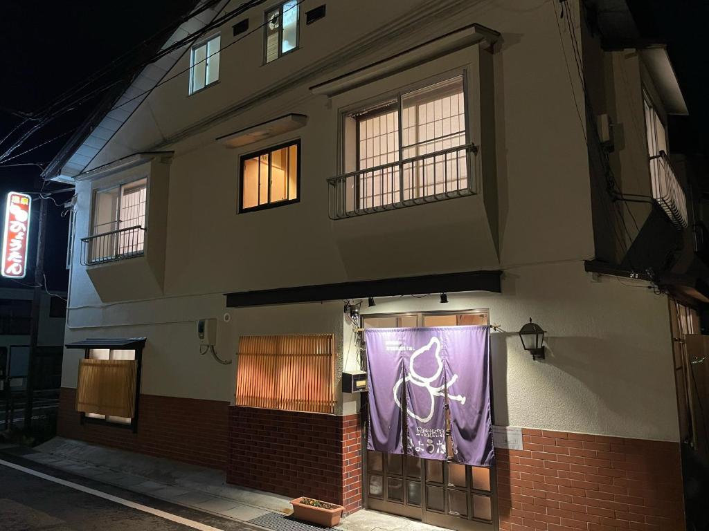 a building with a purple banner on the side of it at Hot Spring Inn Hyoutan in Kusatsu