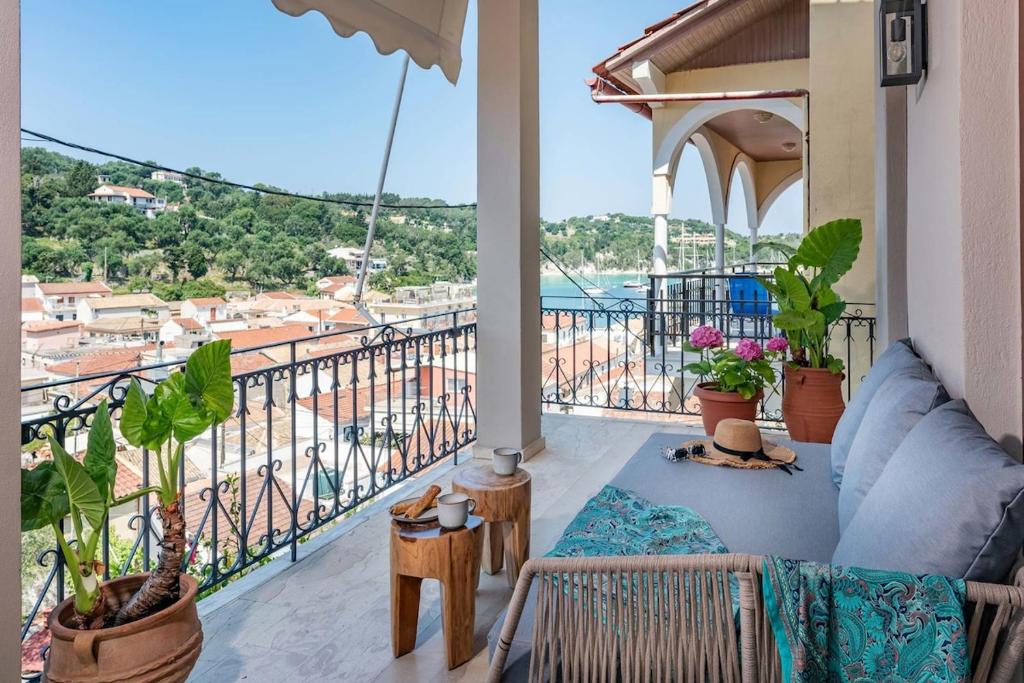 a balcony with a couch and a view of the ocean at Asmira Apartment by PaxosRetreats in Lákka
