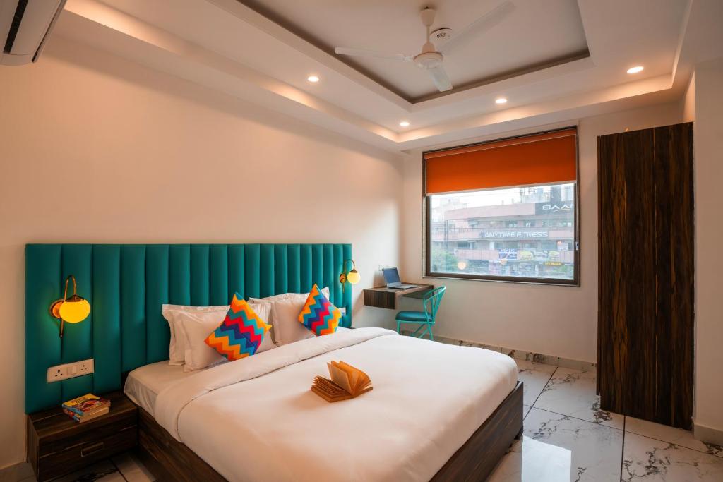Postel nebo postele na pokoji v ubytování goSTOPS PLUS Gurugram, Baani Square