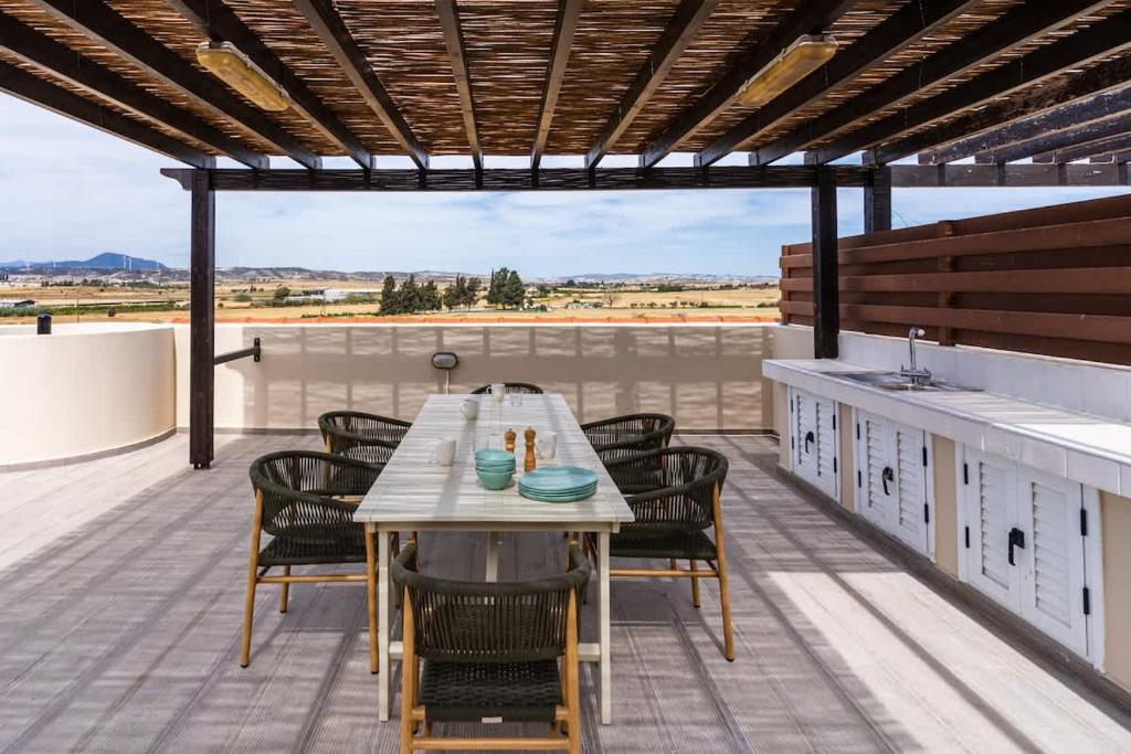 a patio with a table and chairs on a roof at Penthouse Apartment with Amazing View in Kiti in Kiti