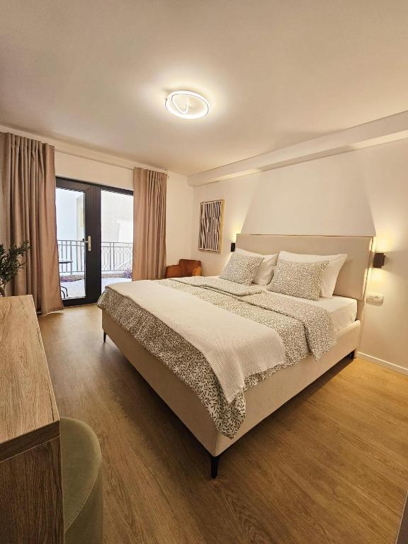 a bedroom with a large bed and a large window at Lendas Apartments & Rooms in Baška Voda
