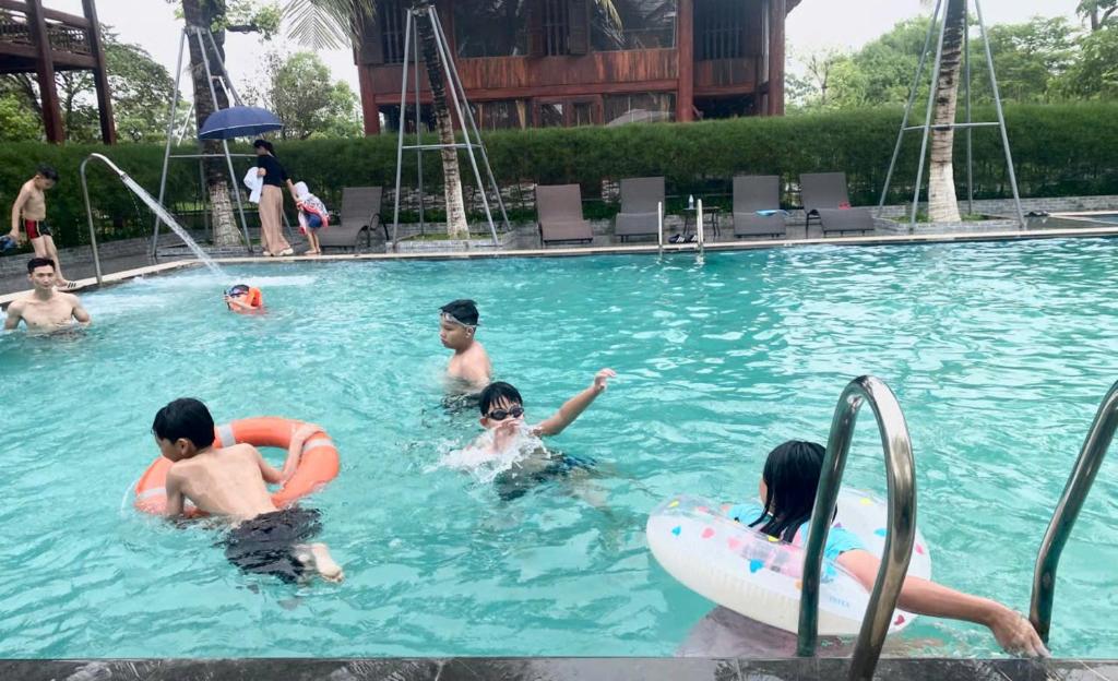 a group of people in a swimming pool at Khu DL ST Cánh Đồng Vàng in Yên Ha