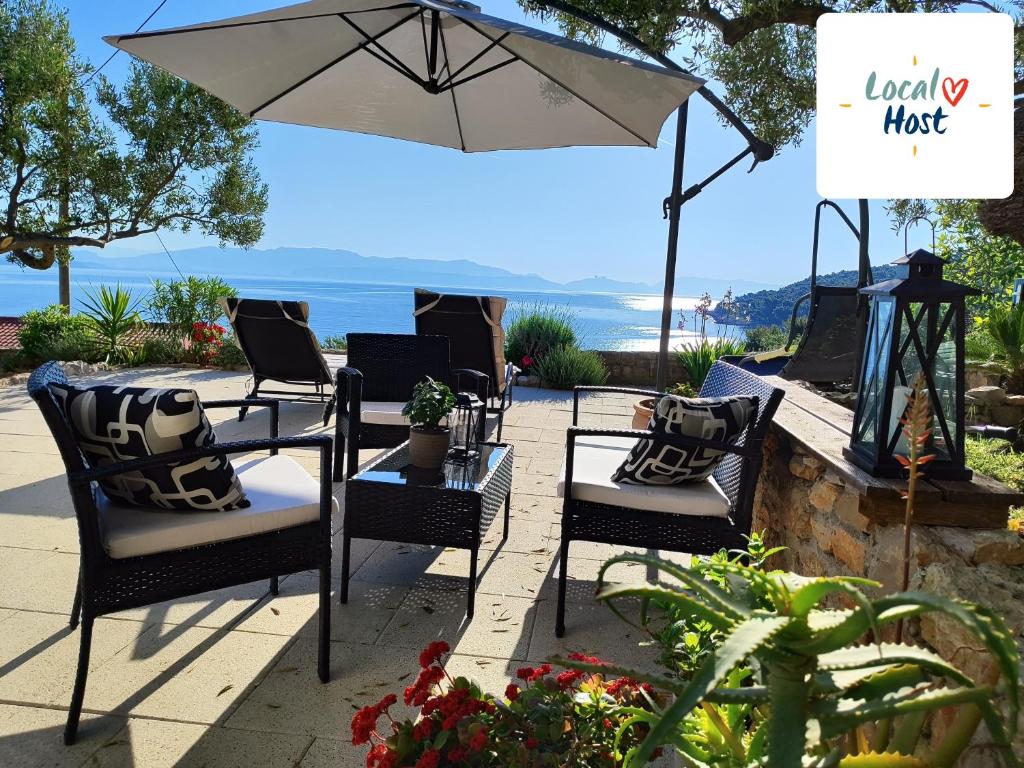 patio z krzesłami i stołem z parasolem w obiekcie Weekend house Olive garden w mieście Donje Selo na Šolti