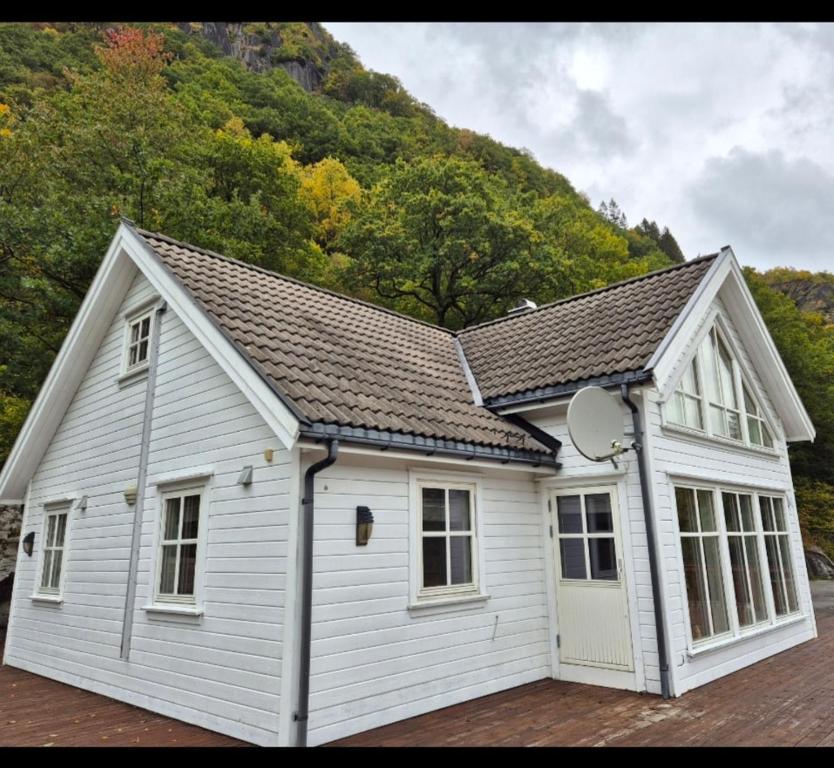 a white garage with a roof and windows at Roligheten hytte in Farsund