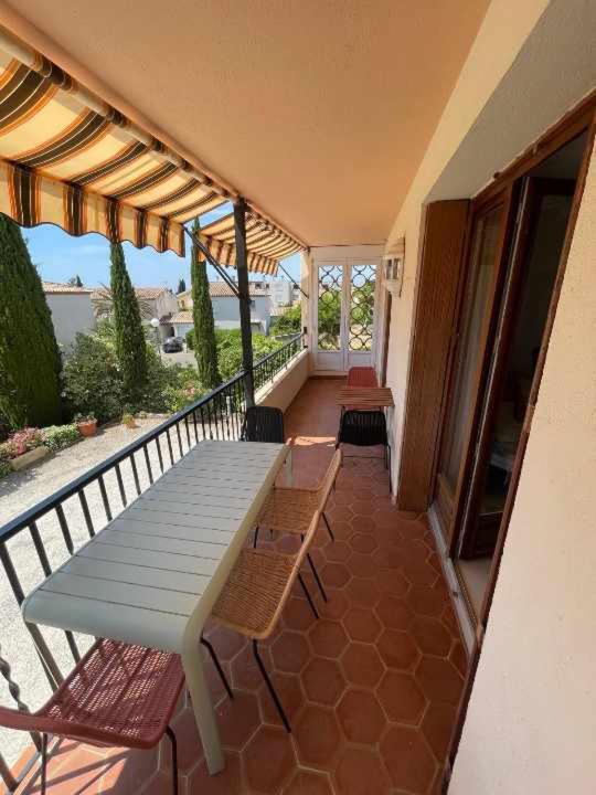 un porche avec une table et des chaises sur un balcon dans l'établissement Appartement T3 proche centre et Renécros-Garage, à Bandol