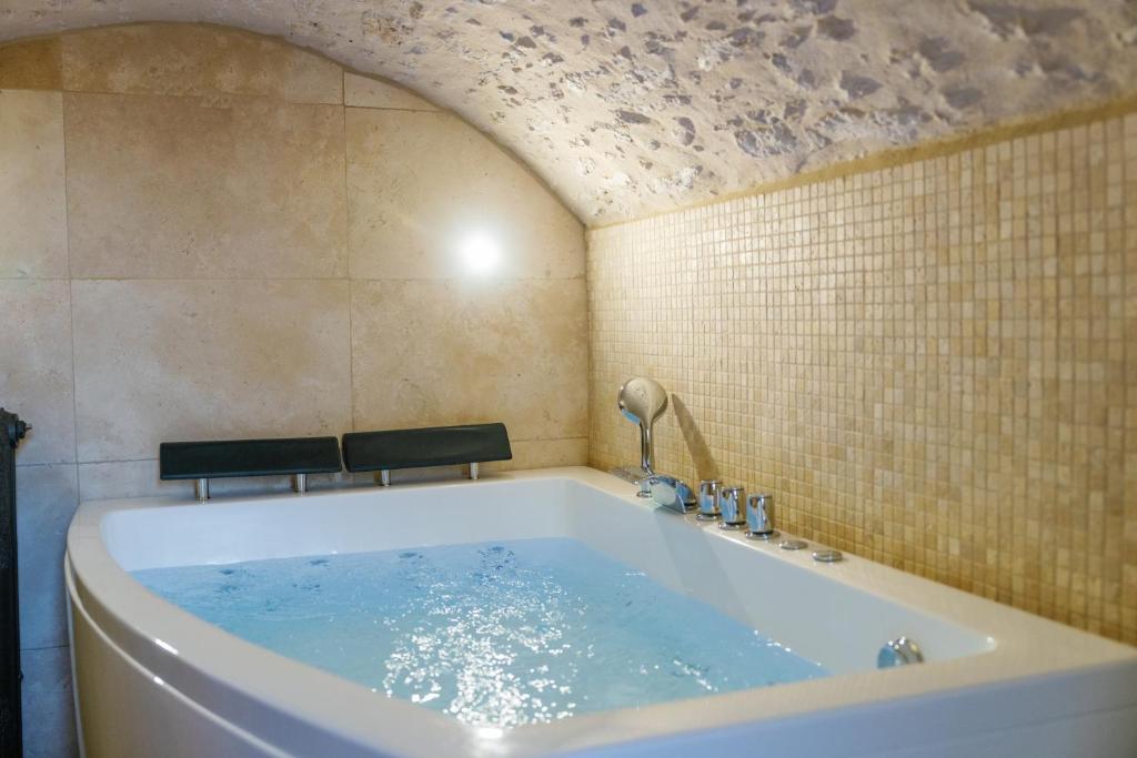 e bagno con vasca e soffitto. di L’Oxalis villa, Sauna et Jaccuzi privatif a Bullion