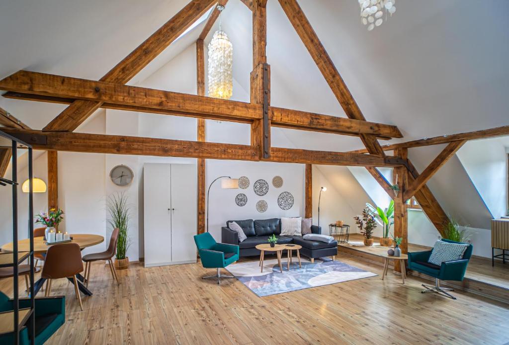 a living room with wooden ceilings and blue chairs at Loft Ferienwohnung in Aschersleben