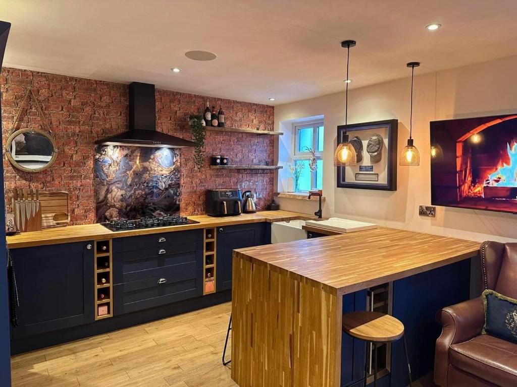 a kitchen with blue cabinets and a wooden counter top at Executive 1bd 1st floor flat in Caerleon