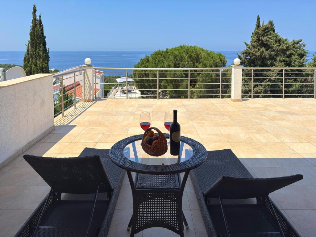 a table with two glasses of wine on a balcony at Blue Seagull in Utjeha