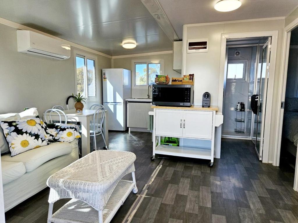 a small living room with a couch and a kitchen at Tiny Cottage by the Lake in Waranga