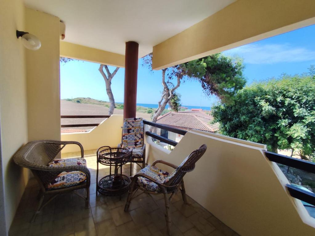 balkon z krzesłami i widokiem na ocean w obiekcie Villa Italia w mieście Tarent