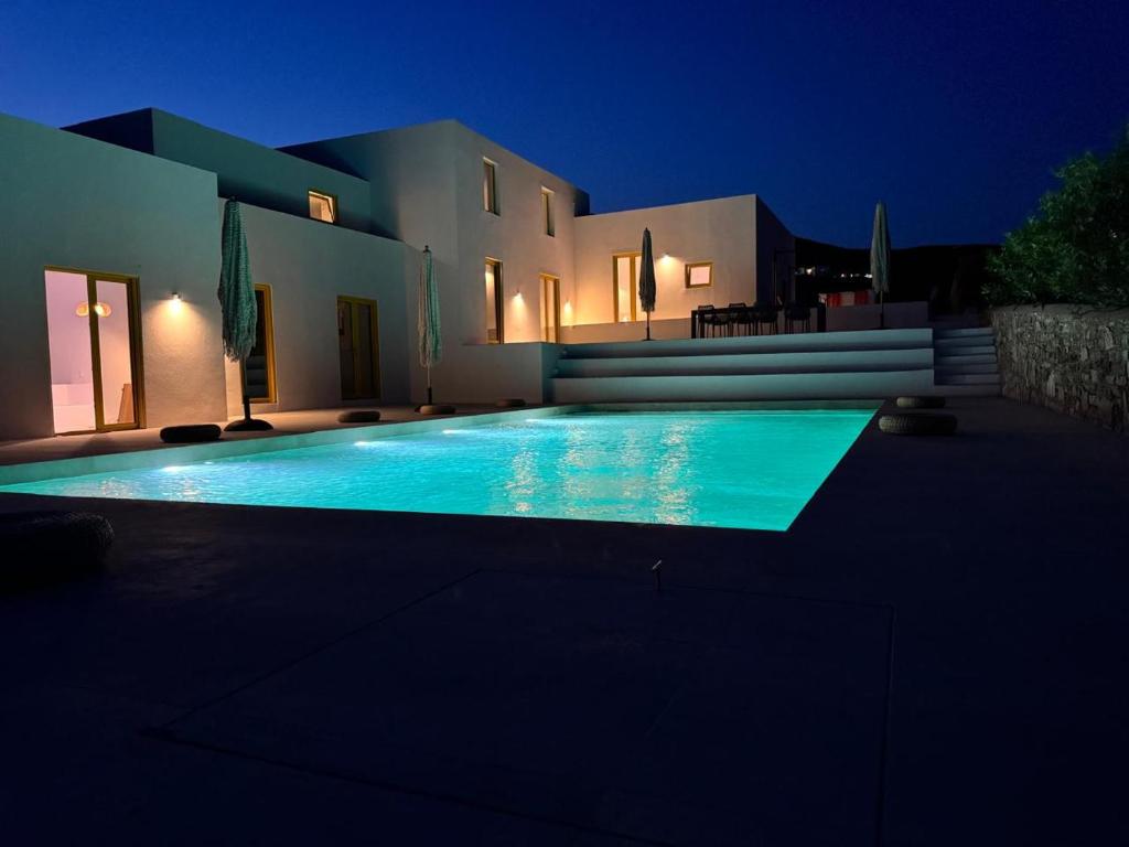 a swimming pool in front of a house at night at Antiparos Gems in Agios Georgios