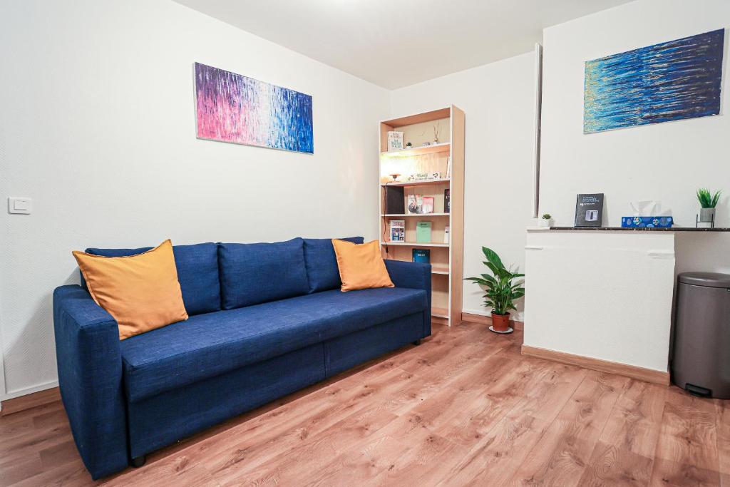 - un salon avec un canapé bleu et une étagère à livres dans l'établissement Appartement très cosy quartier Notre-Dame, Panthéon, Saint-Germain-des-Prés, à Paris