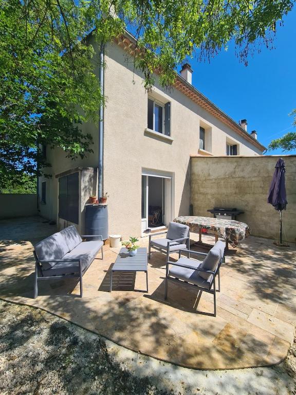 un patio avec des chaises et une table et un bâtiment dans l'établissement Villa avec jardin in Provence, à Pernes-les-Fontaines