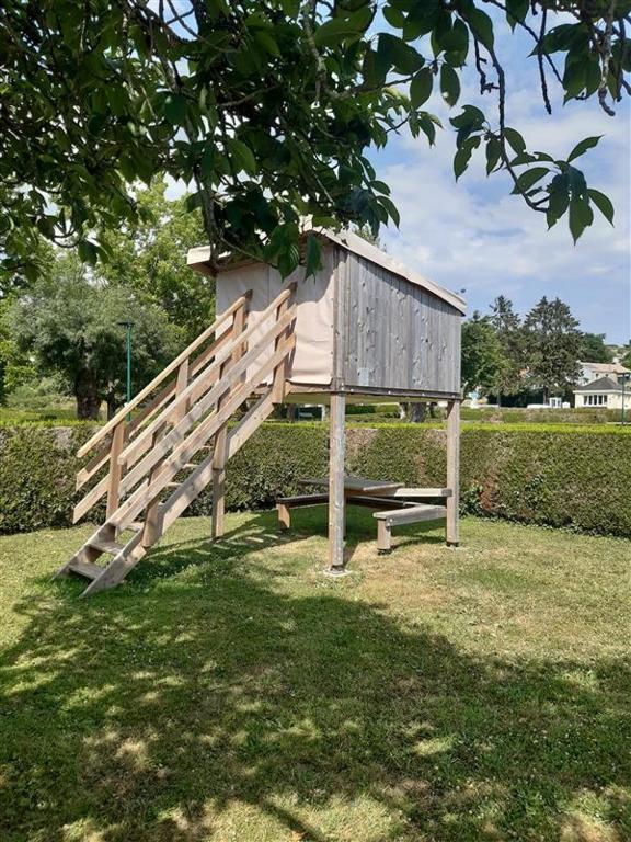 un nichoir en bois posé sur un banc dans l'établissement Camping Onlycamp Les Grenettes, à La Varenne