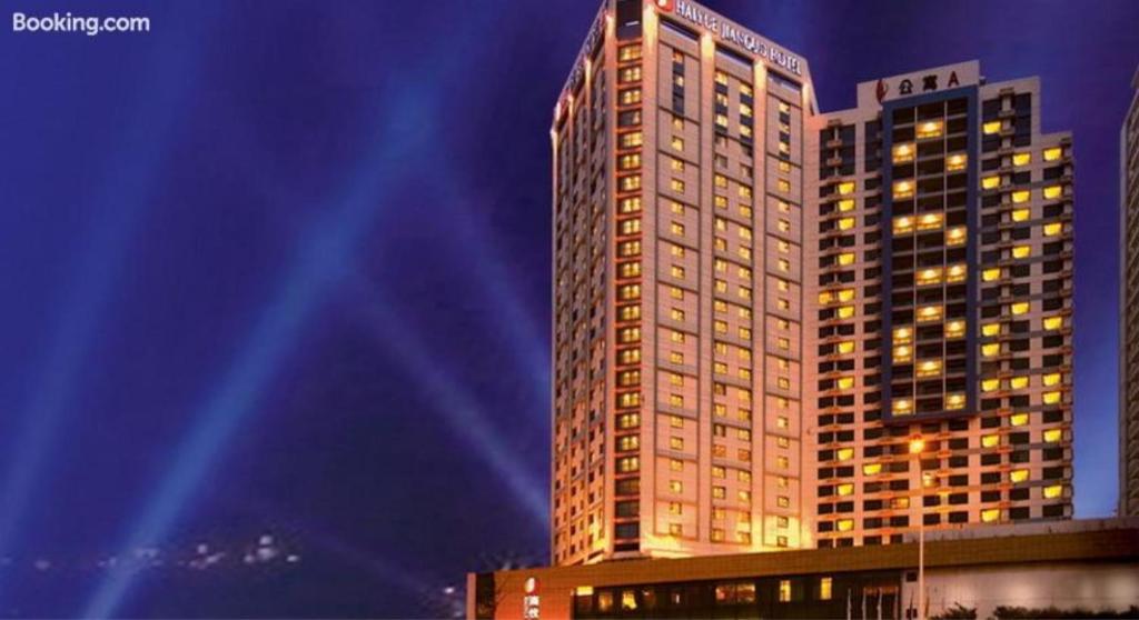 wysoki budynek jest oświetlony w nocy w obiekcie Weihai Haiyue Jianguo Hotel w mieście Weihai