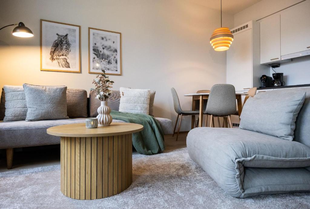 ロヴァニエミにあるStylish Novel Apartments in Lapland - Sauna & Balconyのソファとテーブルのあるリビングルーム