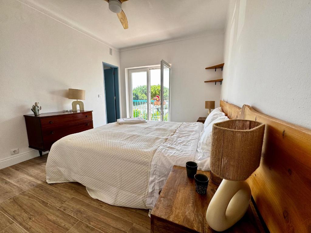a bedroom with a bed and a table with a lamp at Wild Souls Guesthouse in Ericeira