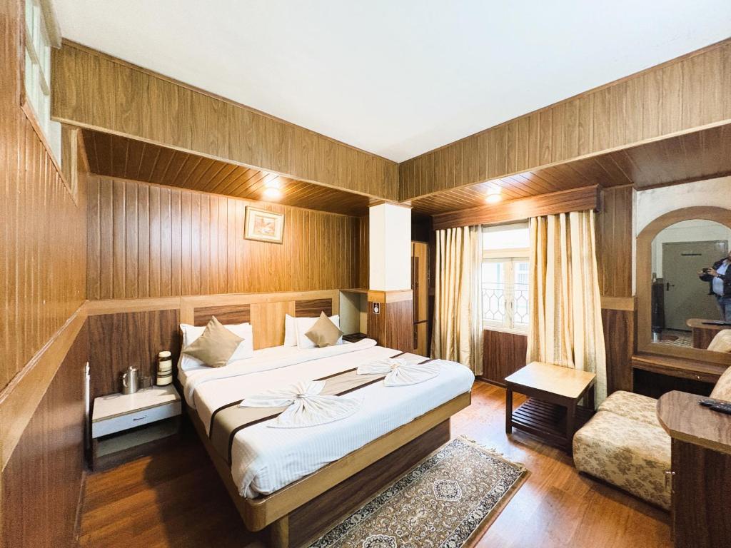 a bedroom with a large bed and a bathroom at Near Chauk Bazaar Marvel International & Restaurant HD Lama Rd in Darjeeling