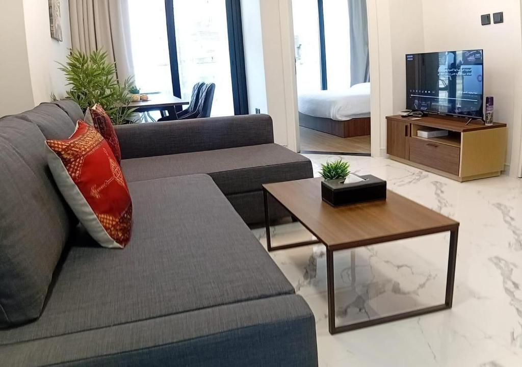 a living room with a couch and a tv at 1 Bed Junior near Cleveland and Galleria Mall by Central Stay in Abu Dhabi