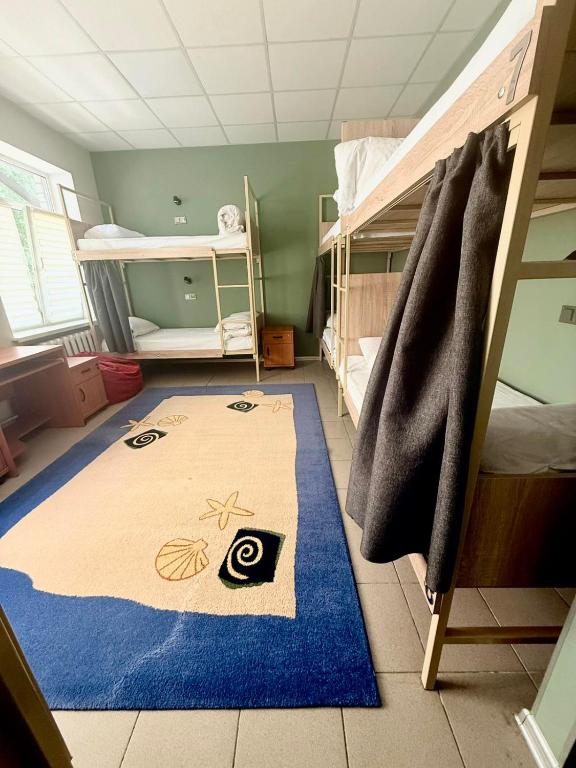 a room with a blue rug and bunk beds at Хостел Vibe Place in Dnipro