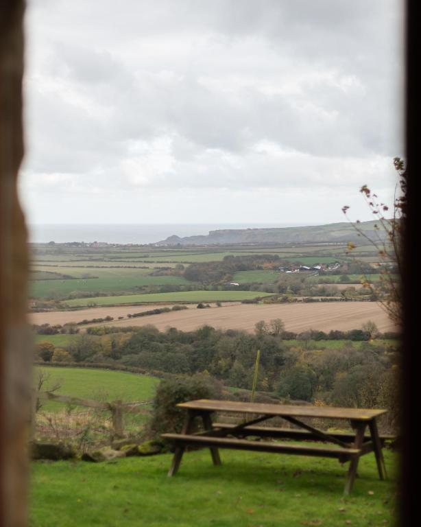 a picnic table sitting on top of a field at Sebright Cottage, Borrowby Farm Cottages in Staithes