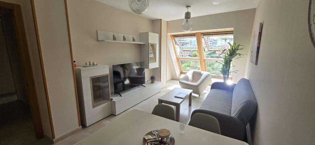 a living room with a couch and a table at Ático Paraíso in San Ciprián