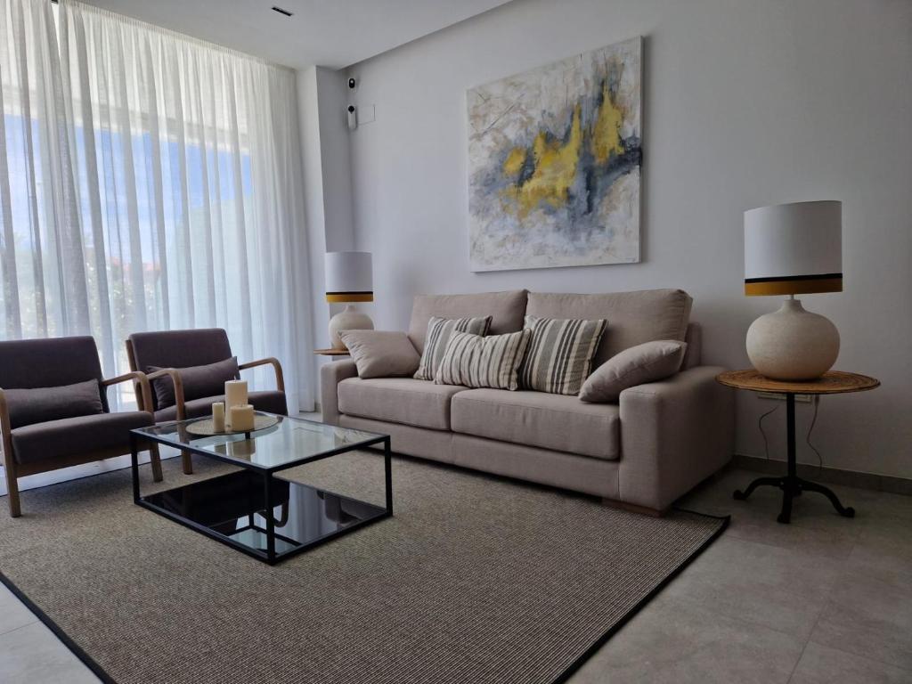 a living room with a couch and a glass table at ELEVENLIGHTS-COSTABALLENA Garden View in Costa Ballena