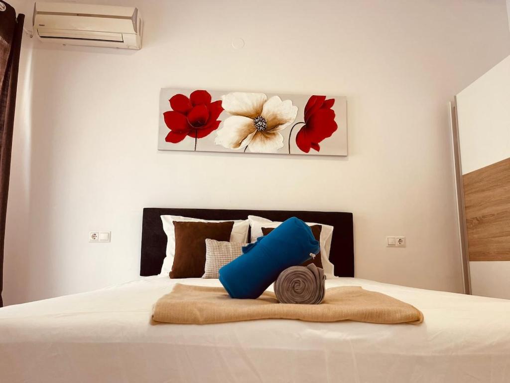 a bedroom with a bed with two paintings on the wall at Ático Fuengirola Playa Centro Ciudad in Fuengirola