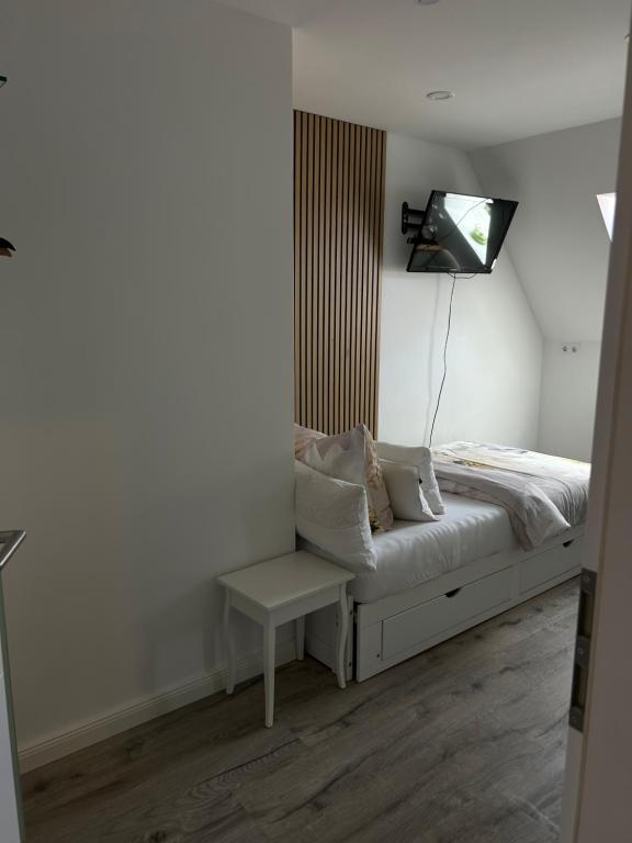 a bedroom with a bed and a tv on the wall at Zimmer mit Küche und Bad in Wedemark