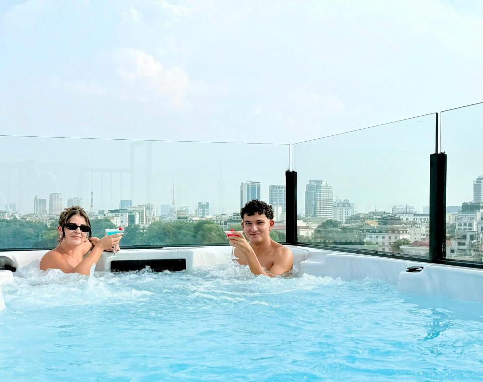 a man and a woman in a hot tub at Lucien Hanoi Lakeside Hotel & Rooftop in Hanoi