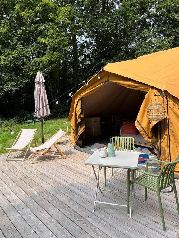 a tent with chairs and a table in front of it at Glamping du Manoir de la Douve in Heuvelland