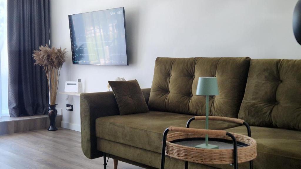 a living room with a couch and a table at Butas su terasa in Šventoji