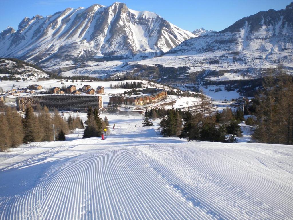 une personne skier sur une piste enneigée avec une montagne dans l'établissement Appart 5-6 pers Superdevoluy, au pied des pistes, à Superdevoluy