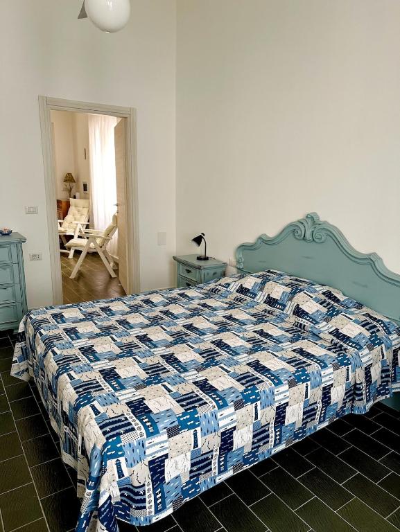 a bedroom with a bed with a blue and white quilt at Il Maestralino, nice apartment with courtyard in Calasetta