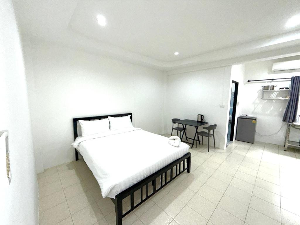 Un dormitorio blanco con una cama y una mesa. en Patong Canal Villa 106, en Patong Beach