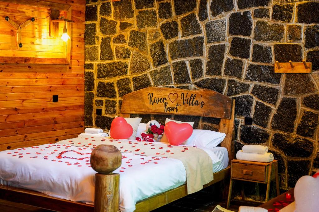 a bedroom with a bed in a stone wall at River Villas Resort in Çamlıhemşin