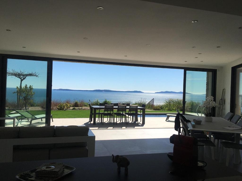 un salon avec une grande baie vitrée dans l'établissement Villa Joya, à Rayol-Canadel-sur-Mer