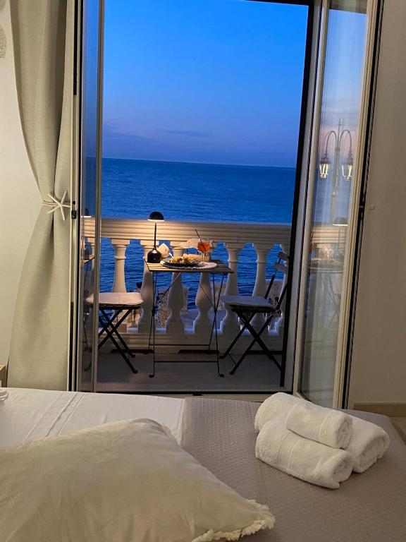 a bedroom with a view of the ocean from a balcony at Aquamaris in Giovinazzo