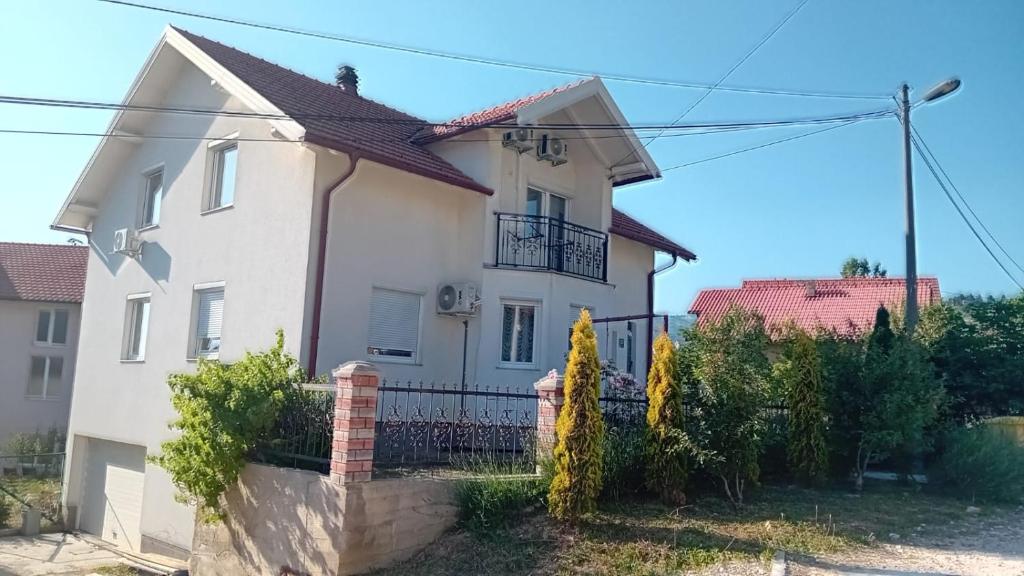 una casa blanca con una valla en Family home EHLI, en Vogošća