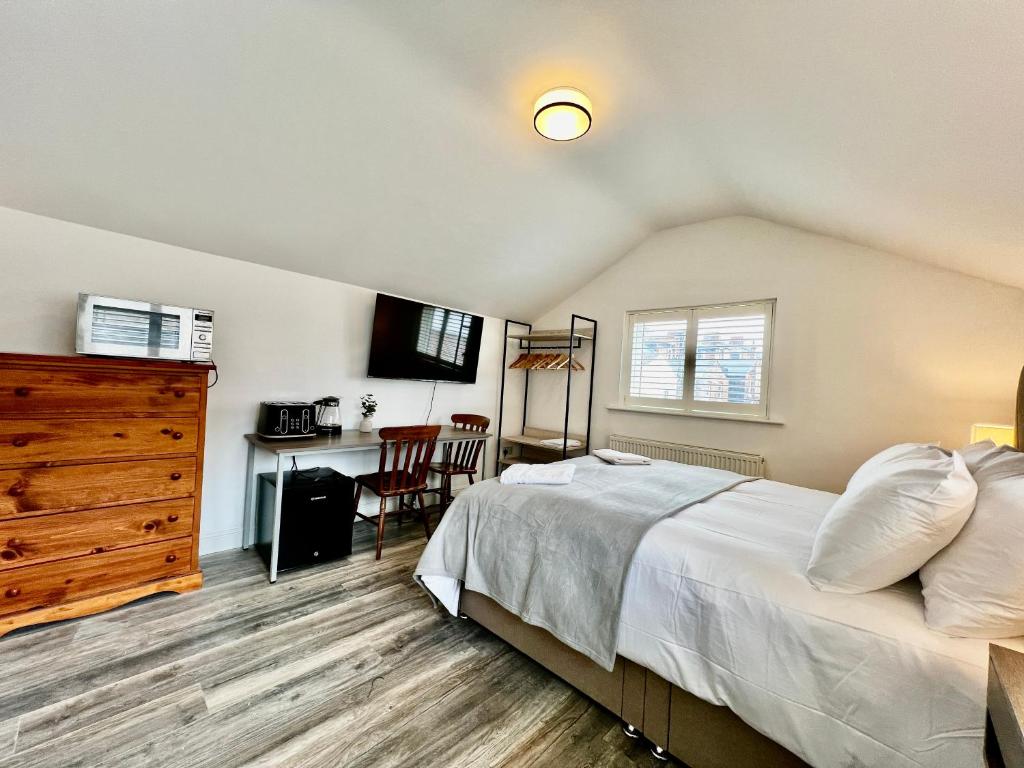 1 dormitorio con 1 cama, vestidor y escritorio en Saltburn Sea Front Penthouse South, en Saltburn-by-the-Sea